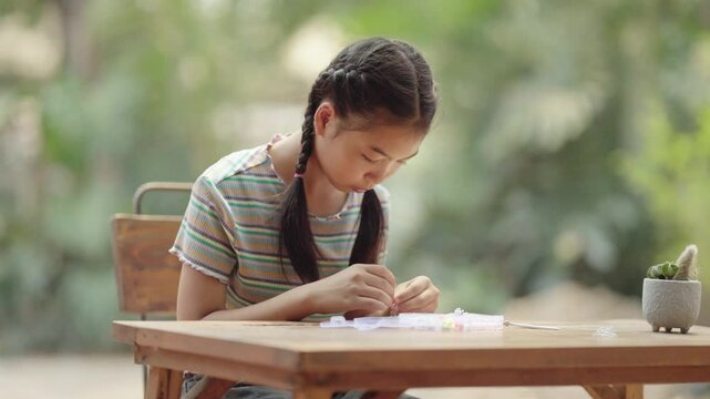 Asian girl making handmade necklace accessories