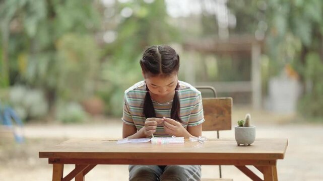 Asian girl making handmade necklace accessories