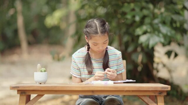 Asian girl making handmade necklace accessories