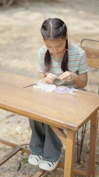 Asian girl making handmade necklace accessories