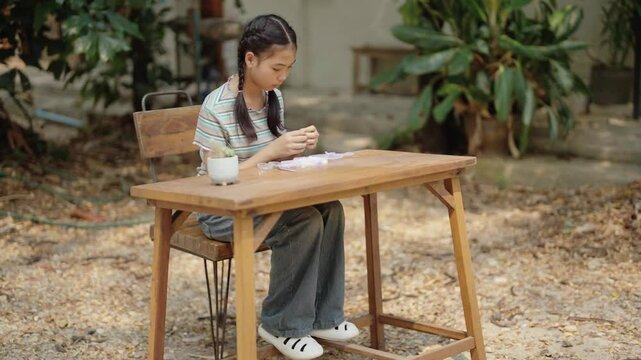 Asian girl making handmade necklace accessories