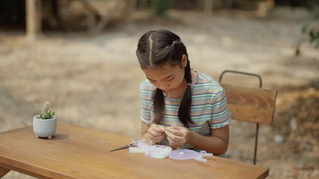 Asian girl making handmade necklace accessories