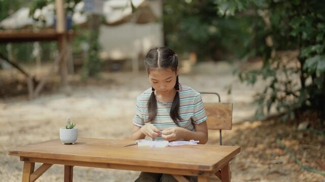 Asian girl making handmade necklace accessories