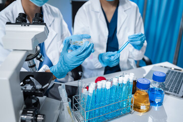 Scientists conducting research in a biotechnology lab, using pipettes and test tubes for medical...