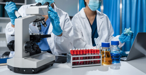 Scientists conducting research in a biotechnology lab, using pipettes and test tubes for medical...