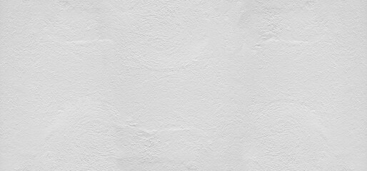 Large white grunge textured concrete wall background. The backdrop is a rough cement floor in gray...