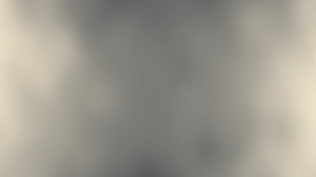 A soft, blurred abstract gray background with gentle gradient transitions and subtle lighting effects.