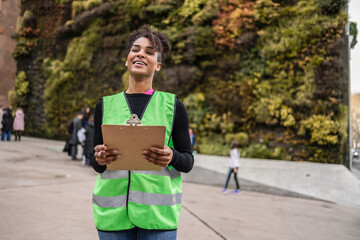 Volunteer with clipboard campaigning outdoors in urban area