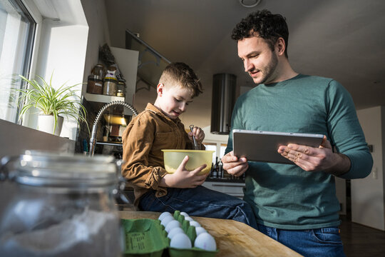 Father and son enjoying quality time cooking together in the kitchen