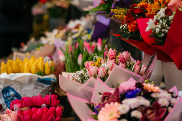 A vibrant assortment of fresh tulips in various shades of pink, purple, and peach, beautifully arranged in bouquets