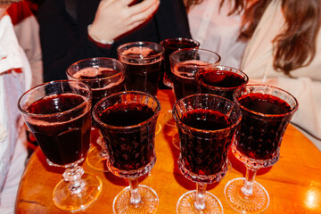 A group of friends raising glasses filled with red wine in a joyful toast, celebrating a special moment together