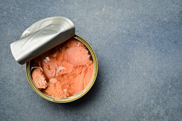 A metal can with tuna in oil. Food stocks. On a gray concrete background.