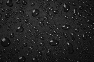 Water drops on a black background. Banner with raindrops. Top view.