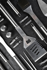 Barbecue and grill set Steel utensils. On a gray concrete background. Top view.