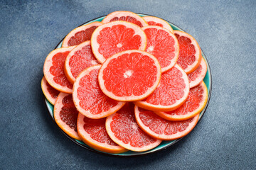 Cut grapefruit slices on a plate ready to eat. Close up macro, top view.