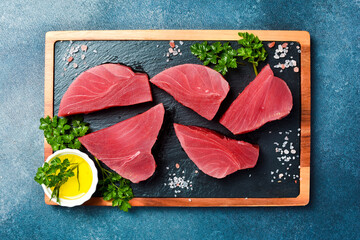 Fresh tuna steaks with sea salt, parsley and butter. Ready to cook. Top view.