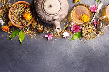 Composition with a cup of tea, a teapot and a set of aromatic flower tea. Free space for text.