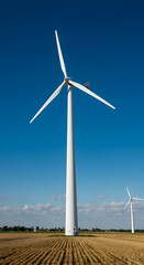 Photo Of Windmill In Field Generating Power Against A Blue Sky
