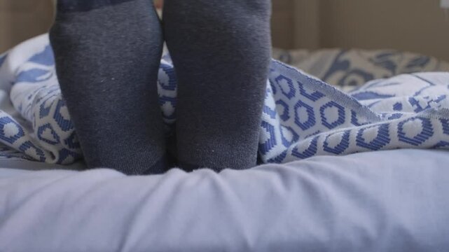 man in socks in bed close up
