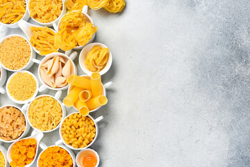 Pasta background. Set of uncooked macaroni in white ceramic bowls. Wide selection.