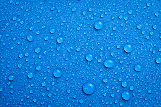 Close up of water droplets on blue background. Macro photo. Top view.