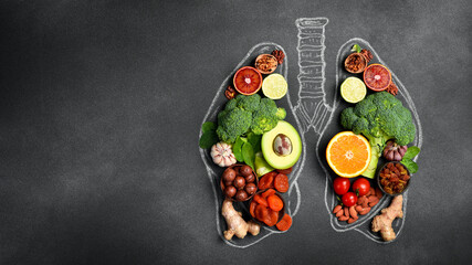 Conceptual image of fruits, vegetables and nuts for lung and breathing health. On black monochrome background. Top view.