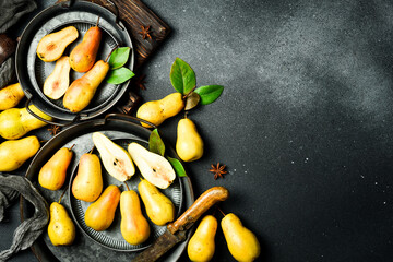 pears in a plate and slices of pears top view. Gray stone table. Autumn fruits.