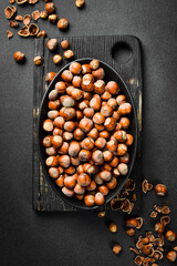 Nuts background. Hazelnuts in a black oval bowl. Healthy Eating. Close up.
