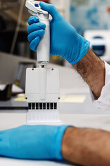 Scientist using multichannel micropipette for clinical laboratory analysis