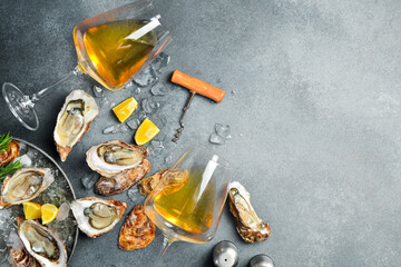 Composition of wine, glasses and fresh open oysters. Healthy sea food. on a gray textured stone background. Free space for text.