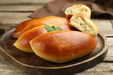 Tasty baked patties with potato and parsley on wooden table, closeup