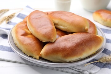 Tasty baked patties and spikelets on white wooden table, closeup