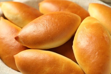 Many tasty baked patties in basket, closeup
