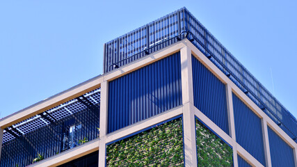 Green office building with plants on the facade. Ecology and green living in city, urban environment concept. Eco architecture. 