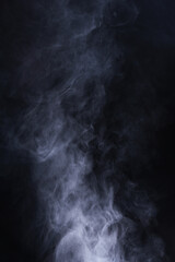 Abstract smoke texture over black background. Fog in the darkness.