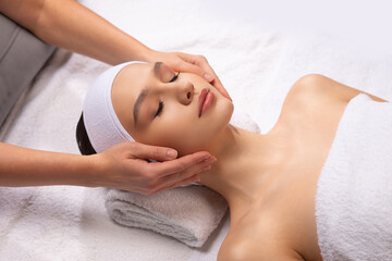 Young woman getting massaging treatment over white background. Spa, healthcare and recreation concept.