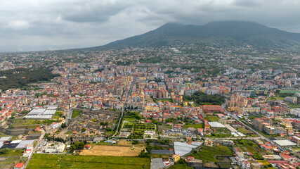 Aerial view of the archaeological area of ​​the excavations of Herculaneum. It was an ancient Roman city. In the background the modern city of Ercolano and Vesuvius volcano, province of Naples, Italy.