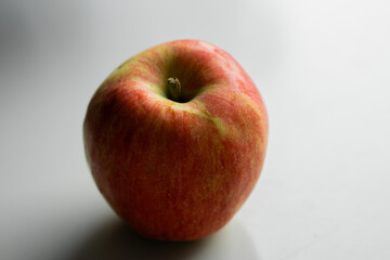A close-up image of a fresh red and green apple with a smooth surface on a white background.