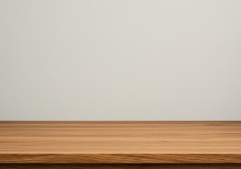 Empty wooden table against a plain white wall background for product display