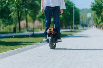 Man with electric unicycle in park on a sunny day closeup view © Alexandr