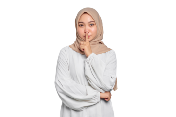 Serious young Asian Muslim woman showing silence gesture with finger isolated on transparent background
