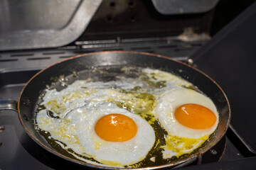 Fried eggs in a frying pan with oil. Two fried eggs.