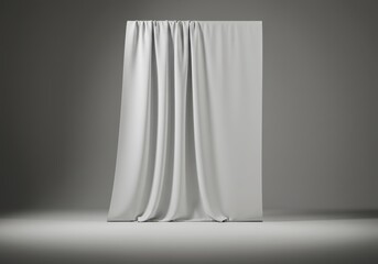 White fabric draped over a rectangular structure in a studio setting with a neutral gray background and soft lighting