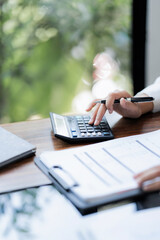 financier analyzing on data paper using calculator at the office workplace