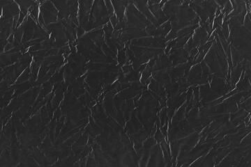 Plastic overlay, distressed, retro texture; grunge background scan for creating nostalgic effect, worn-out, dusty dark scan of crumpled, folded black paper