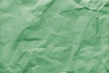 Recycled crumpled green colored paper texture. Wrinkled craft paper background, rough cardboard surface, wallpaper, backdrop. Design element, copy space for text