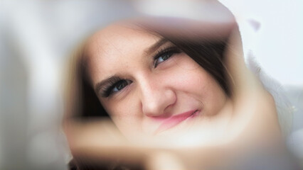 In a stylish moment, a young girl captures attention by posing through a creative frame, highlighting her fashionable outfit and confident expression