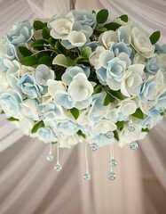 Hanging decorative floral arrangement featuring blue and white roses with delicate crystal ornaments. Ideal for weddings, celebrations, or interior designs seeking a soft, elegant touch.

