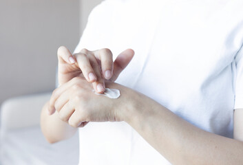 Close up of woman applying cream or ointment on swollen skin after insect bites