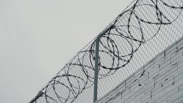 Security systems restricted area. Sharp razor blades on barbed wire. Prison wall. High quality 4k footage